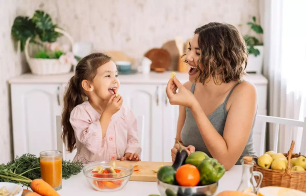 mamá comiendo vegetales con hija